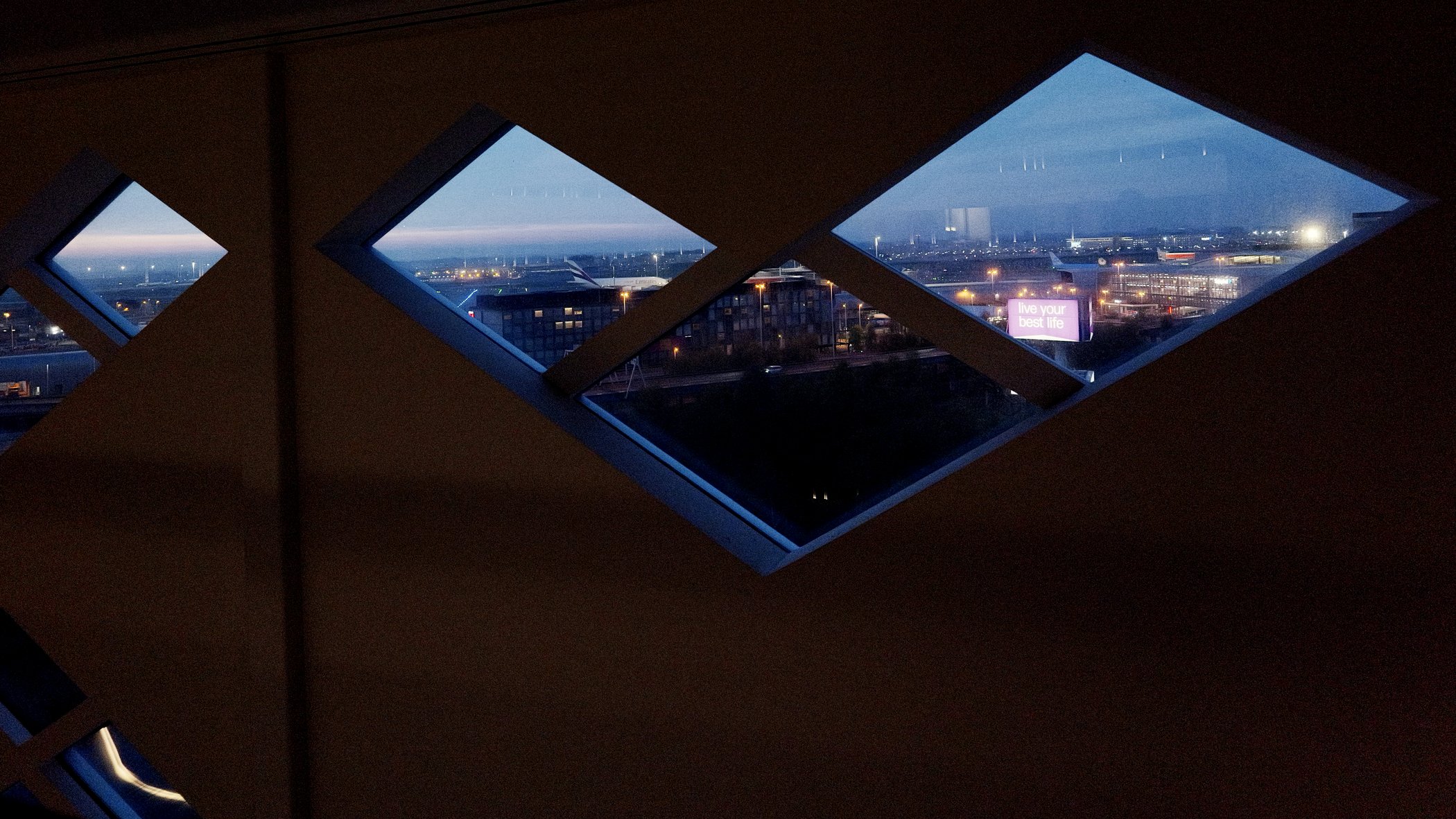 Airport landscape framed through diamond-shaped windows