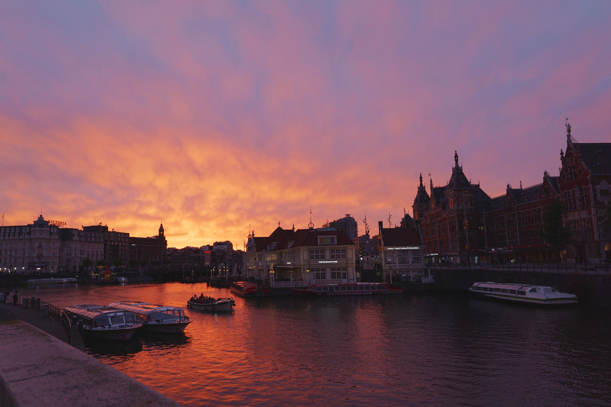 Orange and pink sunset over Amsterdam waterfront architecture