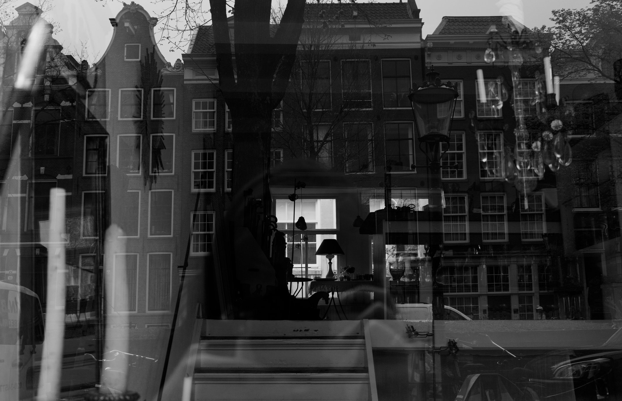 Interior and Amsterdam buildings layered in a window reflection