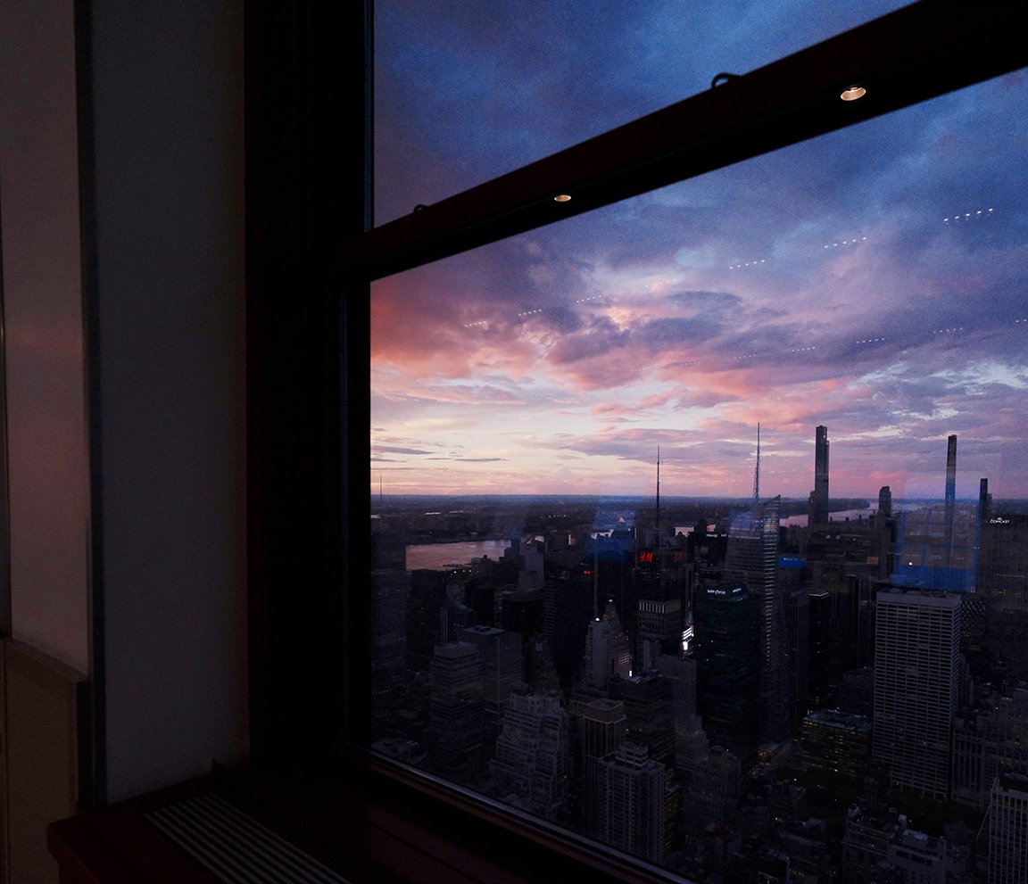 New York skyline and sunset viewed through a reflective window