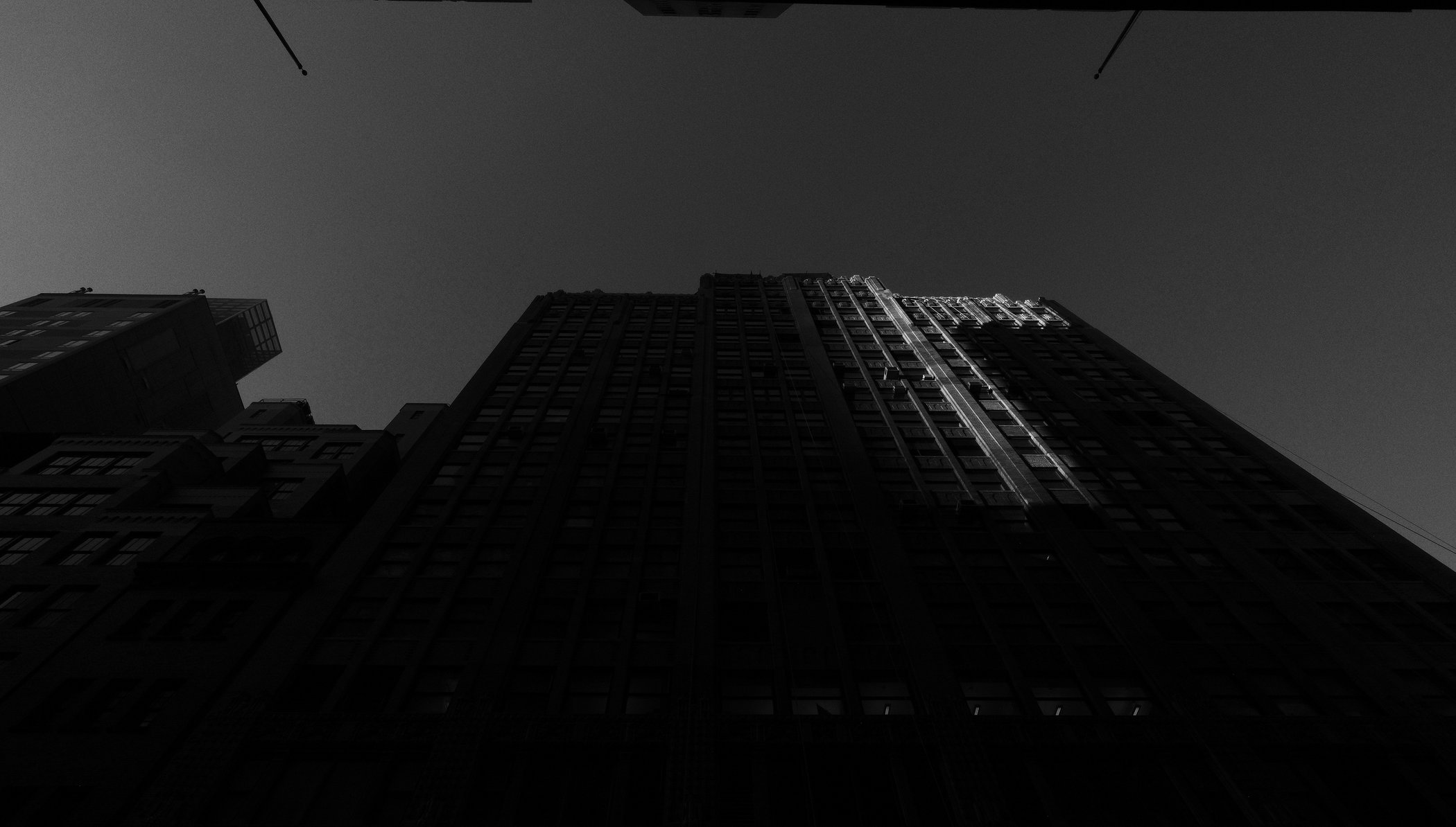 Narrow band of light running up a dark city tower